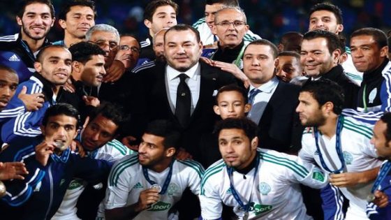 Moroccan King Mohammed VI, center, poses for a group photo with the team of Raja Casablanca after Bayern won the final of the soccer Club World Cup between FC Bayern Munich and Raja Casablanca in Marrakech, Morocco, Saturday, Dec. 21, 2013. (AP Photo/Matthias Schrader)