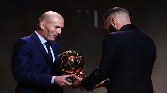 Real Madrid's French forward Karim Benzema (R) receives the Ballon d'Or award from French former forward football player Zinedine Zidane during the 2022 Ballon d'Or France Football award ceremony at the Theatre du Chatelet in Paris on October 17, 2022. (Photo by FRANCK FIFE / AFP)