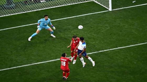 England's midfielder #22 Jude Bellingham (R) scores his team's first goal during the Qatar 2022 World Cup Group B football match between England and Iran at the Khalifa International Stadium in Doha on November 21, 2022. (Photo by Jewel SAMAD / AFP)